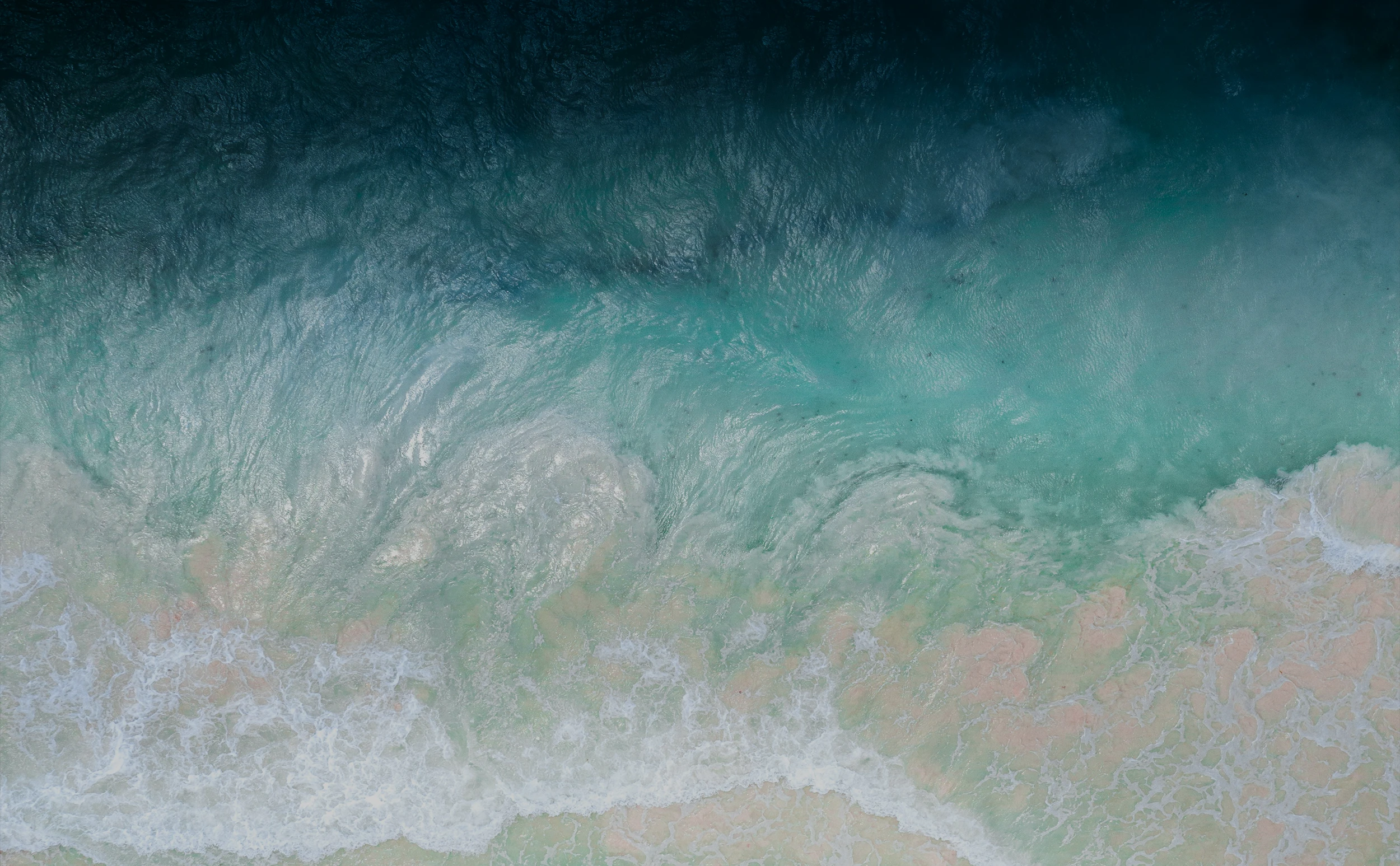 An aerial view of ocean waves on the beach