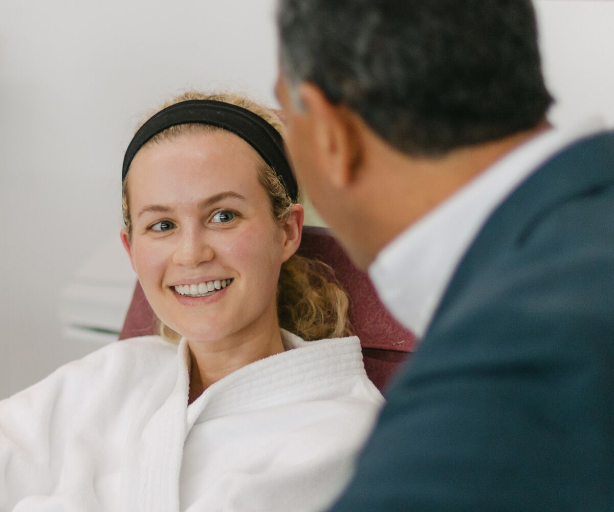 Dr. Tony Jimenez speaking with a smiling patient at Hope4Cancer