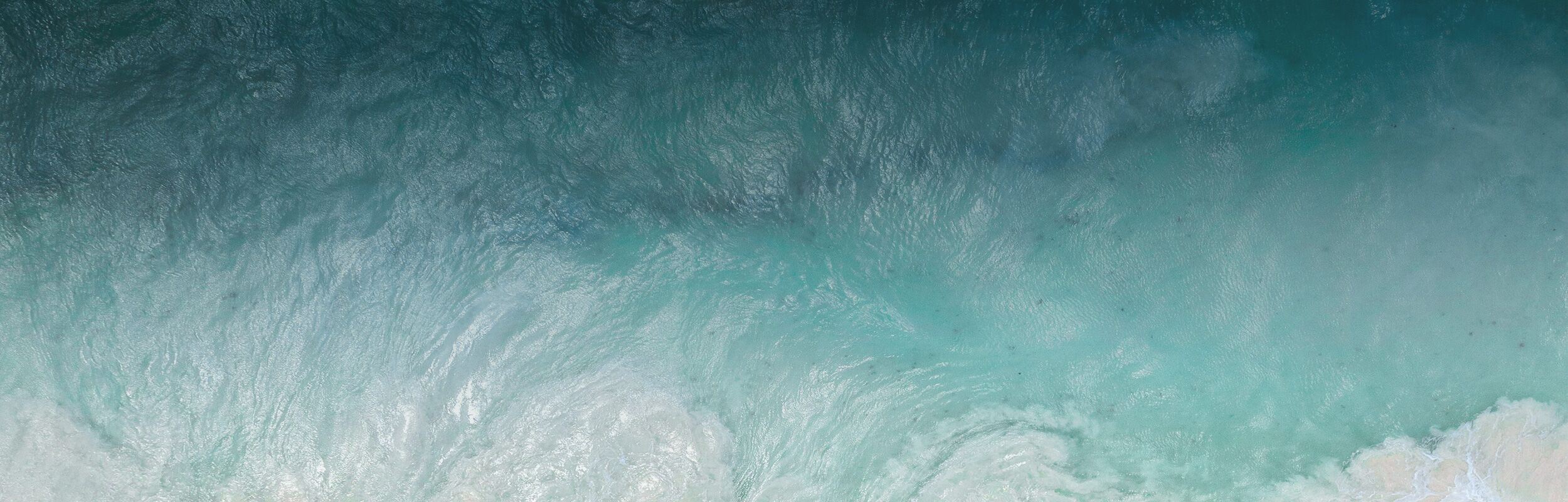 An aerial view of ocean waves on the beach